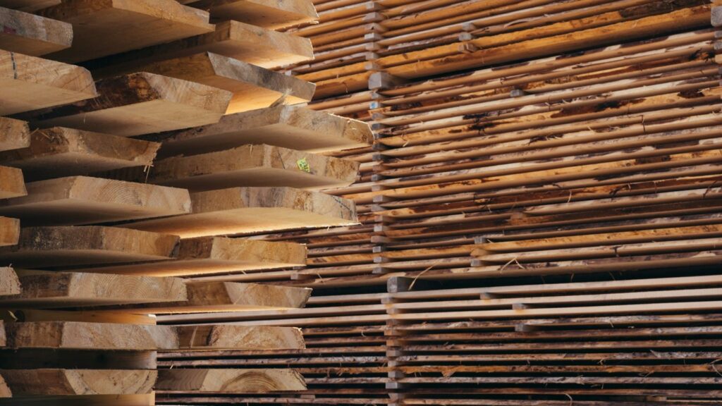 Gestapelde houten planken die worden gedroogd ter voorbereiding op houtwerk schilderen buiten