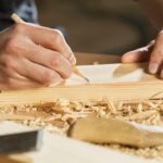 Handen die hout bewerken en markeren als voorbereiding op houtwerk schilderen buiten