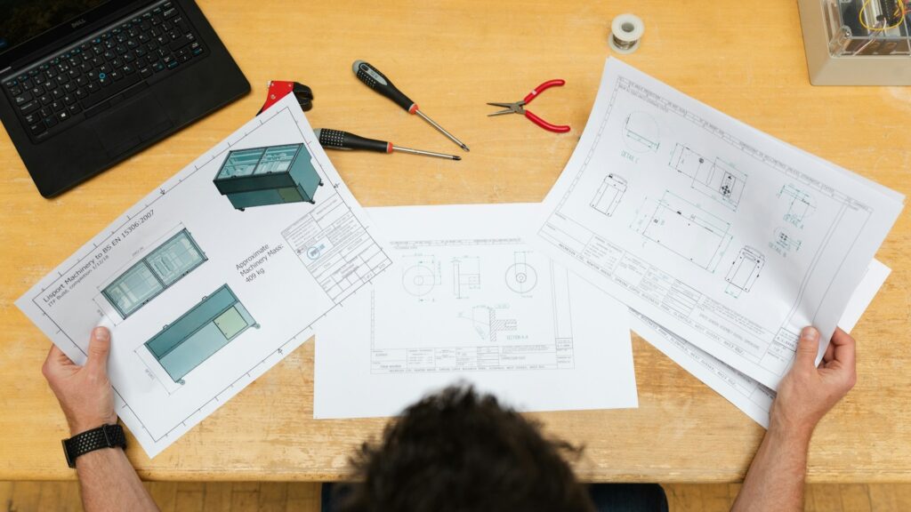 Technische tekeningen en gereedschap op tafel die voorbereiding van interieur bouwkeuzes laten zien