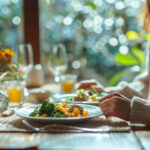 Persoon eet maaltijd aan tafel met aandacht voor eten en drinken in rustige omgeving