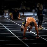 Atleet voert een intensieve oefening uit tijdens HYROX, voorbeeld van kracht en conditie binnen HYROX groeit snel