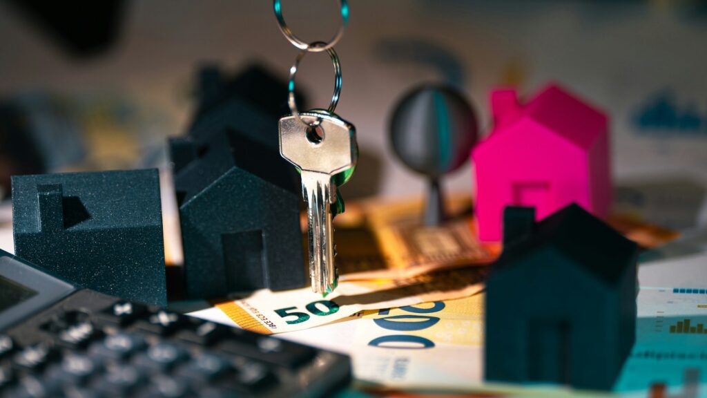 Sleutels en modelhuizen op eurobiljetten als symbool voor huis kopen en financiële keuzes