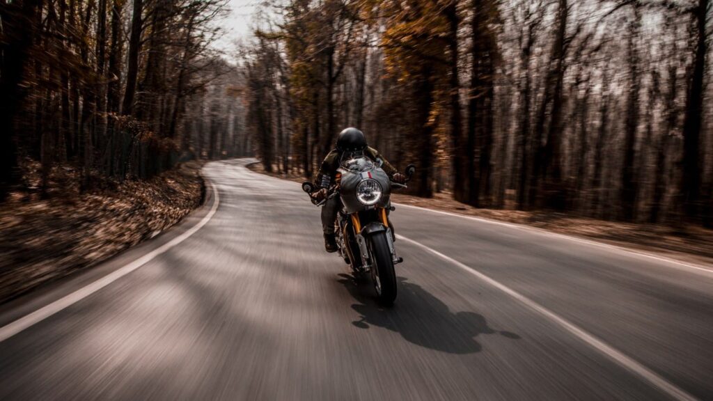 Motorrijder in bocht op bosweg waarbij techniek en focus belangrijk zijn bij beginnende motorrijders fouten