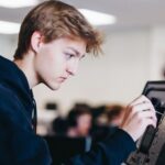 Student werkt met technologie in onderwijs aan hardware tijdens praktijkles